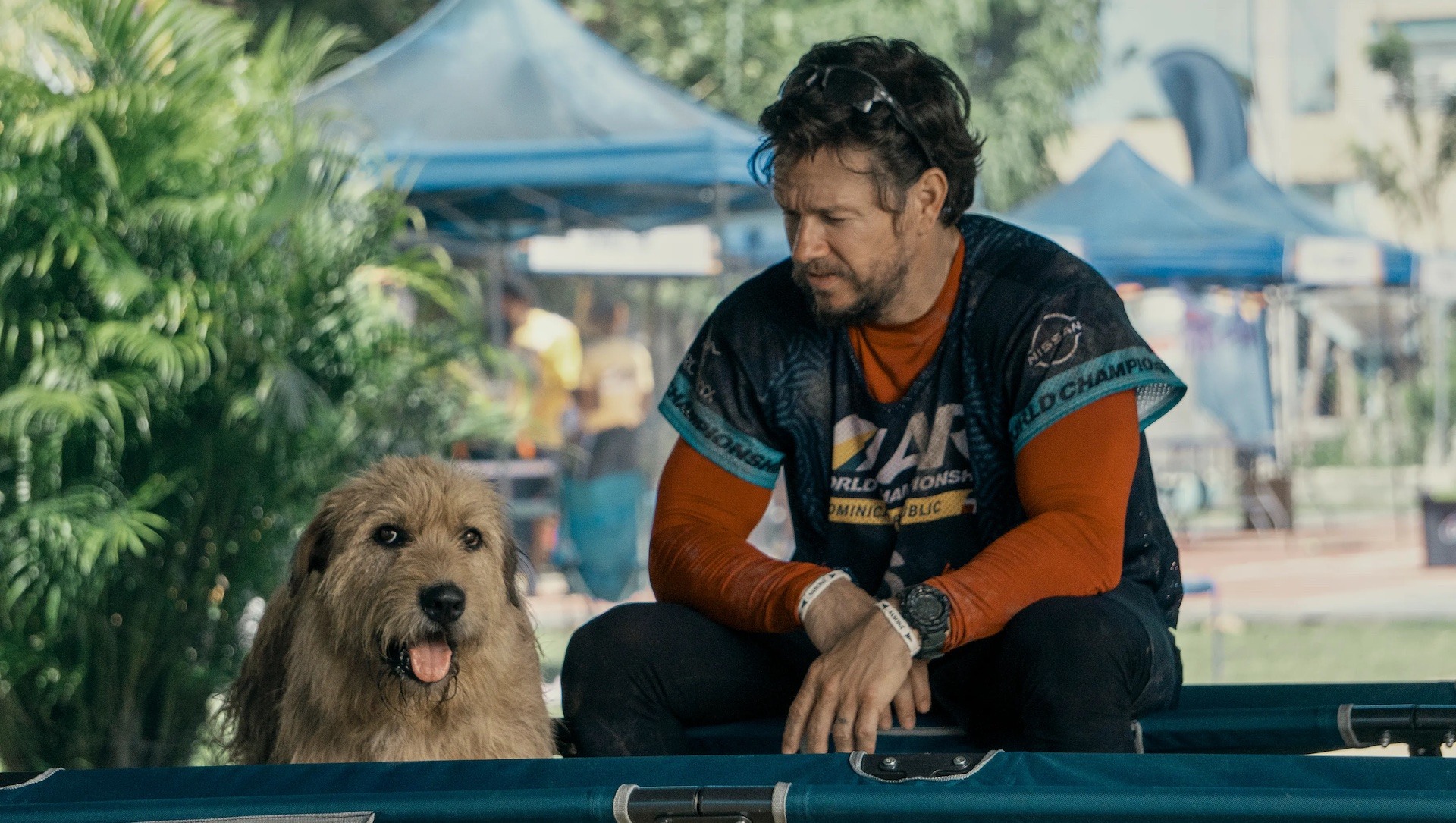 Mark Wahlberg as Michael Light with a dog during a race in 'Arthur the King'