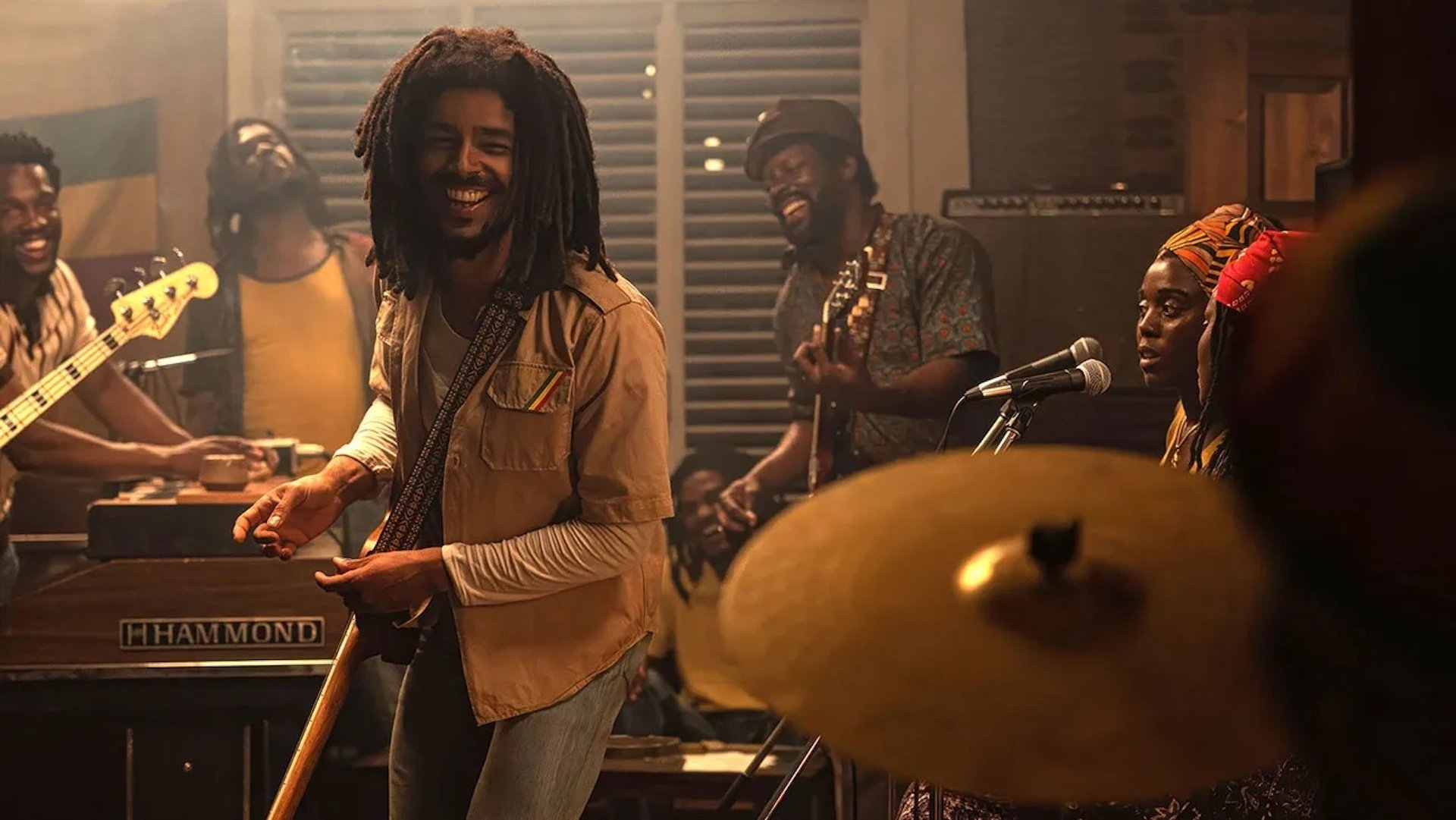 Bob Marley (Kingsley Ben-Adir) playing in a studio with his band in 'Bob Marley: One Love' 