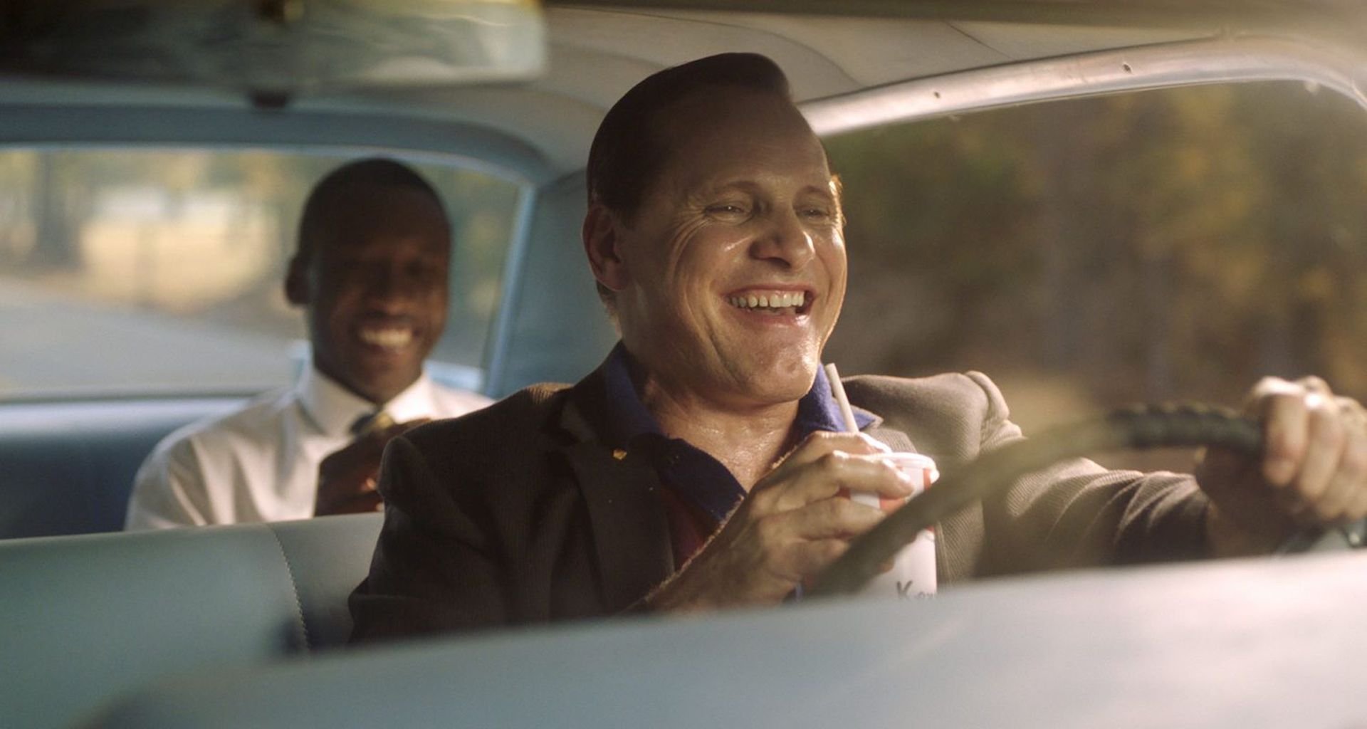 Tony Lip (Viggo Mortensen) laughing and driving with Dr. Don Shirley (Mahershala Ali) in the backseat in 'Green Book'