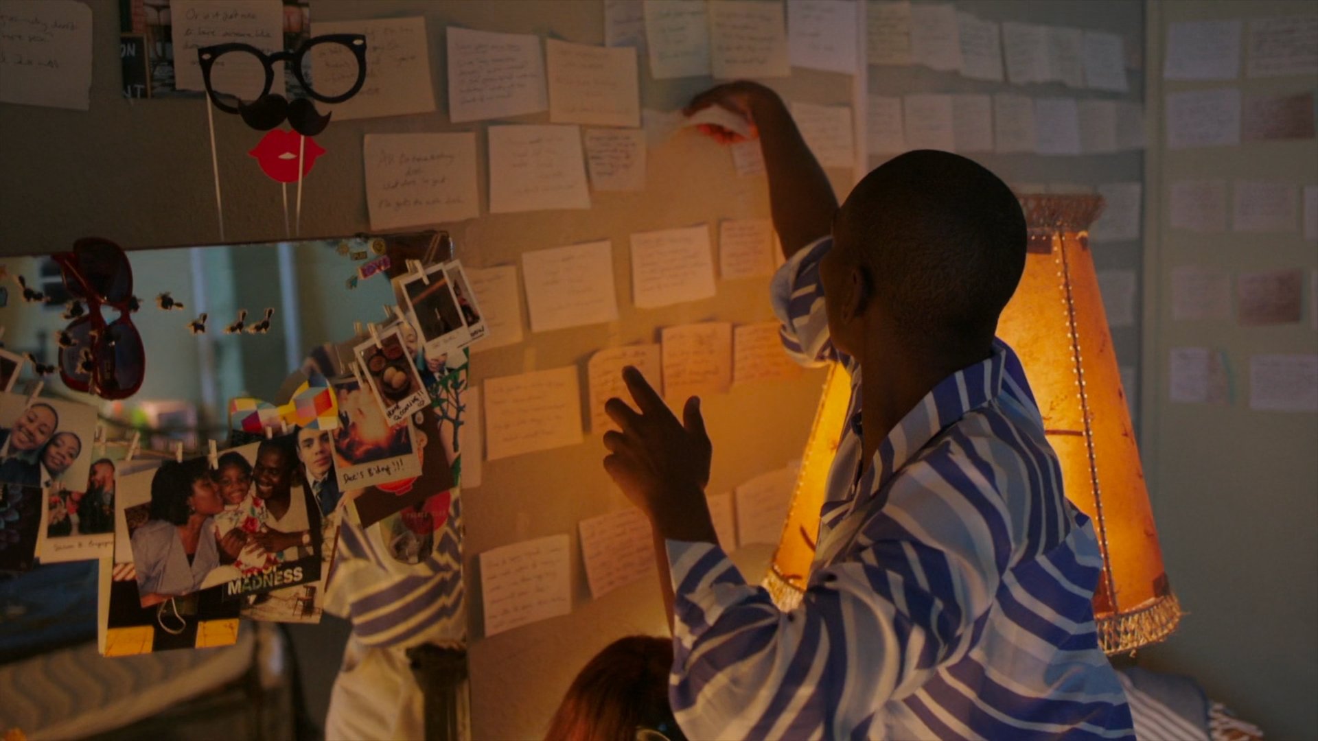 A person hanging notes on a wall in 'I May Destroy You'