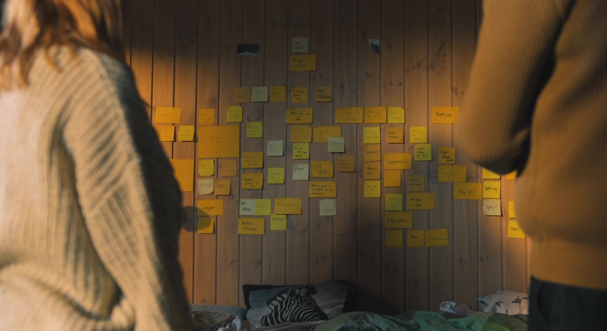 A couple looking at a wall of sticky notes in 'Raiders of Justice' (2021)