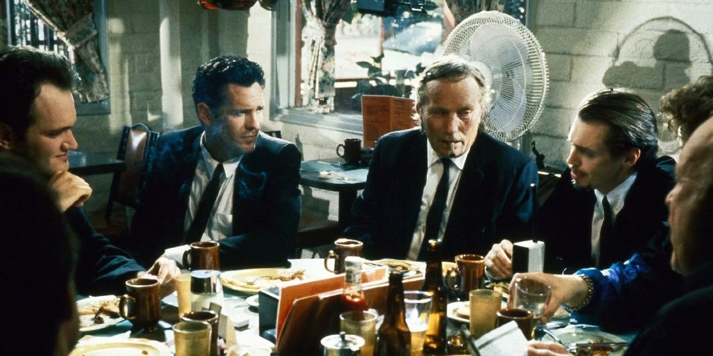 A group of men in suits talking around a table in 'Reservoir Dogs,' How To Use Digressions To Create Natural Sounding Dialogue