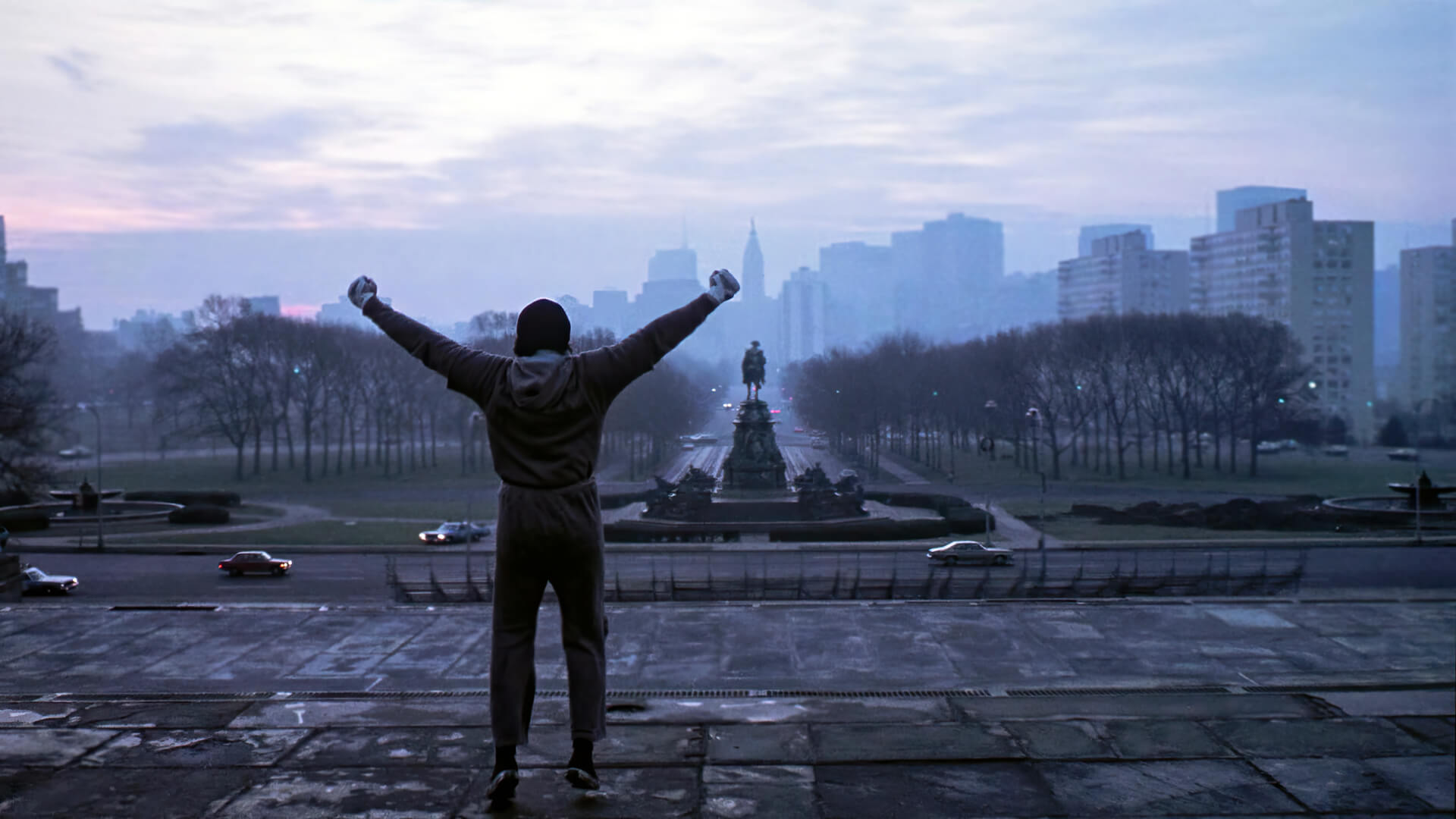 Rocky (Sylvester Stallone) celebrating at the top of a staircase in 'Rocky,' 4 Tips to Never Forget Your Protagonist