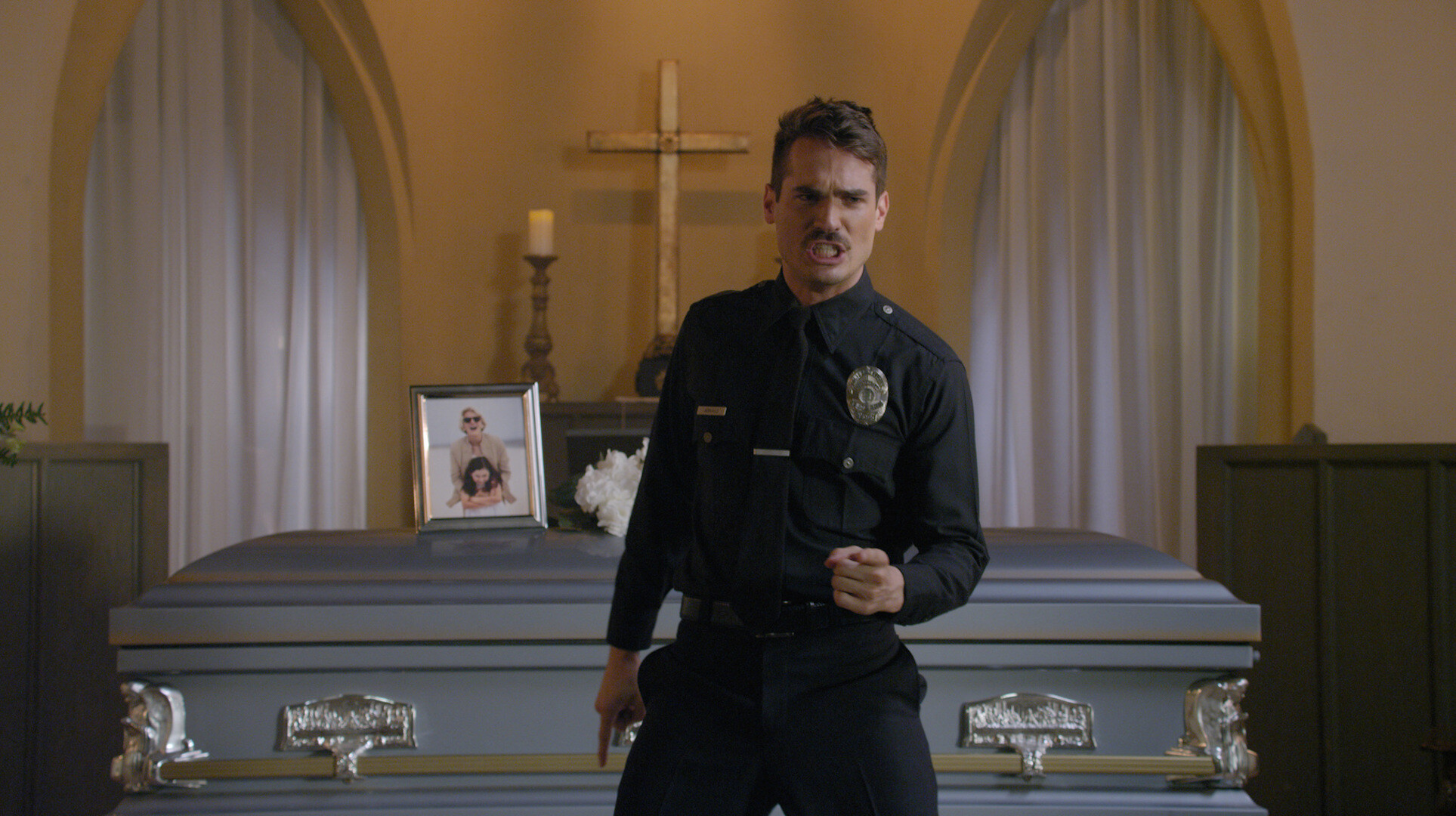 A police officer crying and dancing at a funeral house in 'Thunder Road'