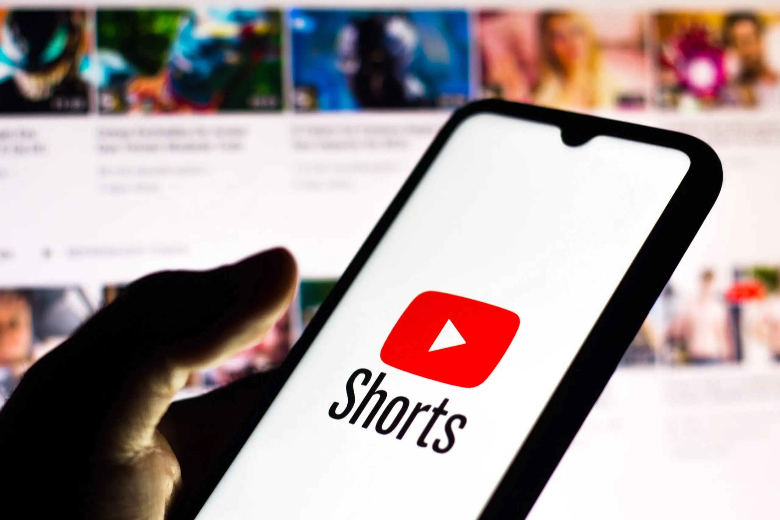 A phone screen projecting YouTube Shorts while YouTube is on the TV in the background, Adapting to Online Trends: Writing Content for TikTok and Shorts